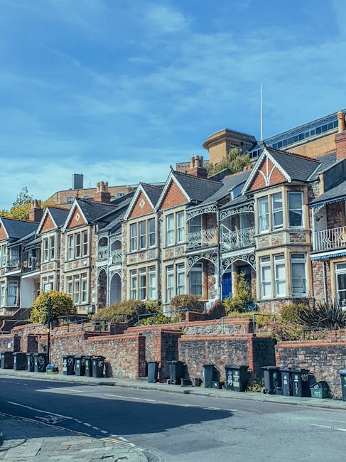 A row of Victorian-style terraced houses situated on a residential street in Islington, London, with brick facades, decorative white railings on the small front balconies, and large sash windows. The 