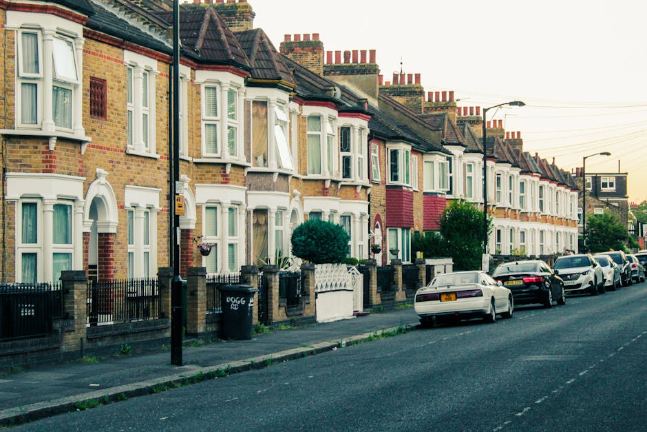A row of Victorian-style terraced houses situated on a residential street in Islington, London, with brick facades, decorative white railings on the small front balconies, and large sash windows. The 